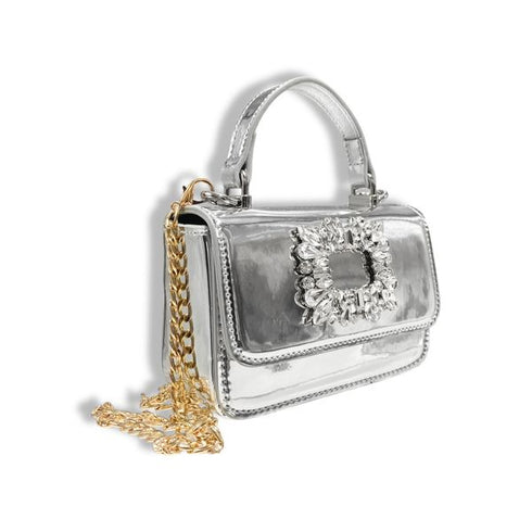 Silver handbag with decorative clasp and gold chain on a white background
