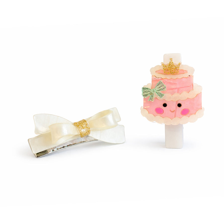 Hair clip with bow and cake-shaped phone stand on a white background