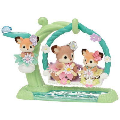 calico critters playset with deer dressed in floral outfits with flowers in their ears. sitting in a floral swing over an imaginary pond