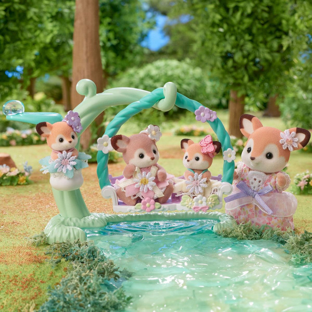 this pictures shows the deer mom and little girls playingin the pretend water while playing on the swing. 