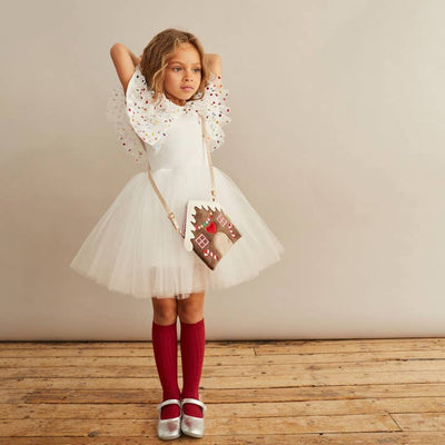 girl wearing holiday dress with a gingerbread handbag 