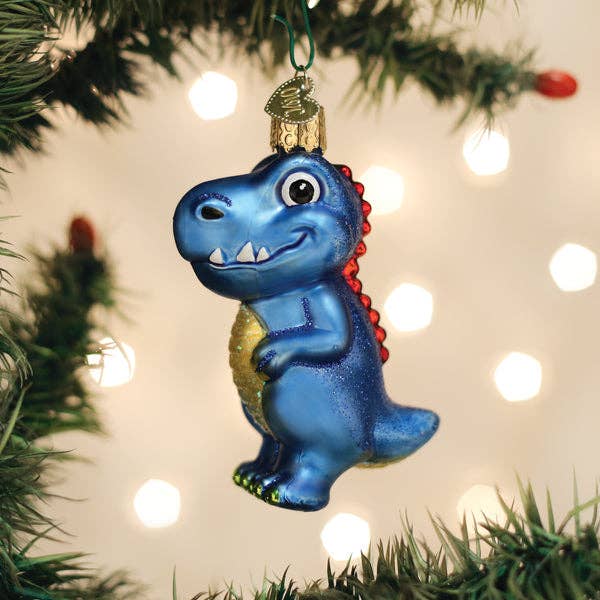 Blue dinosaur ornament on a Christmas tree with lights in the background