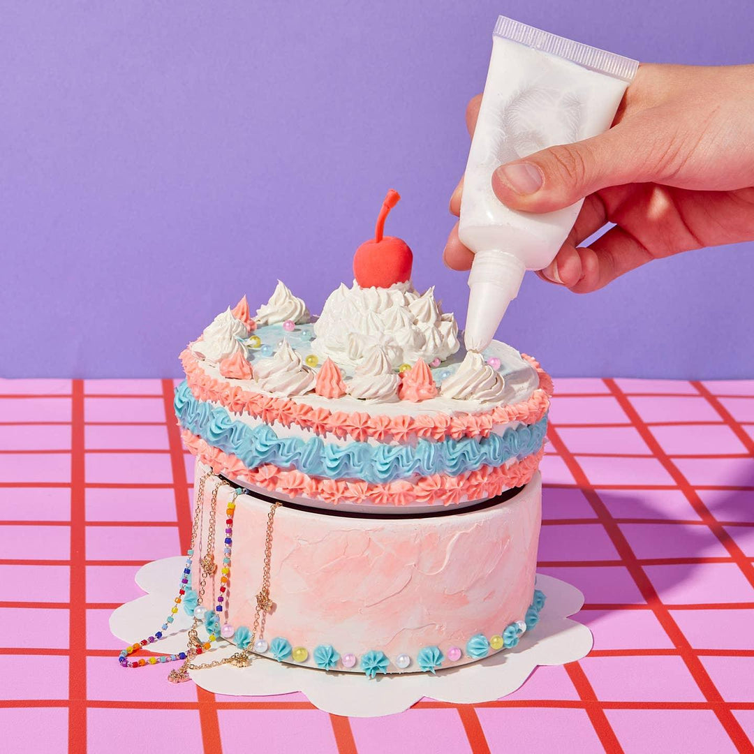 this picture shows someone using a special container to add the frosting to the cake. 