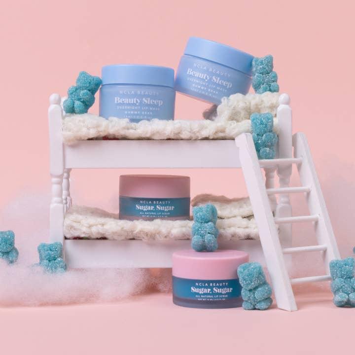 picture of lip mask and lip scrub with blue gummy bears. the lip mask and scrub are both in blue packaging. 