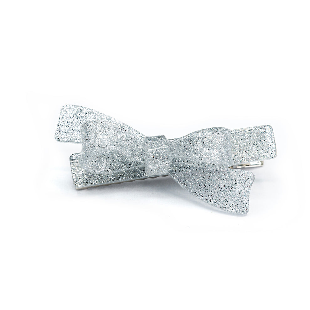 Silver glittery bow hair clip on a white background