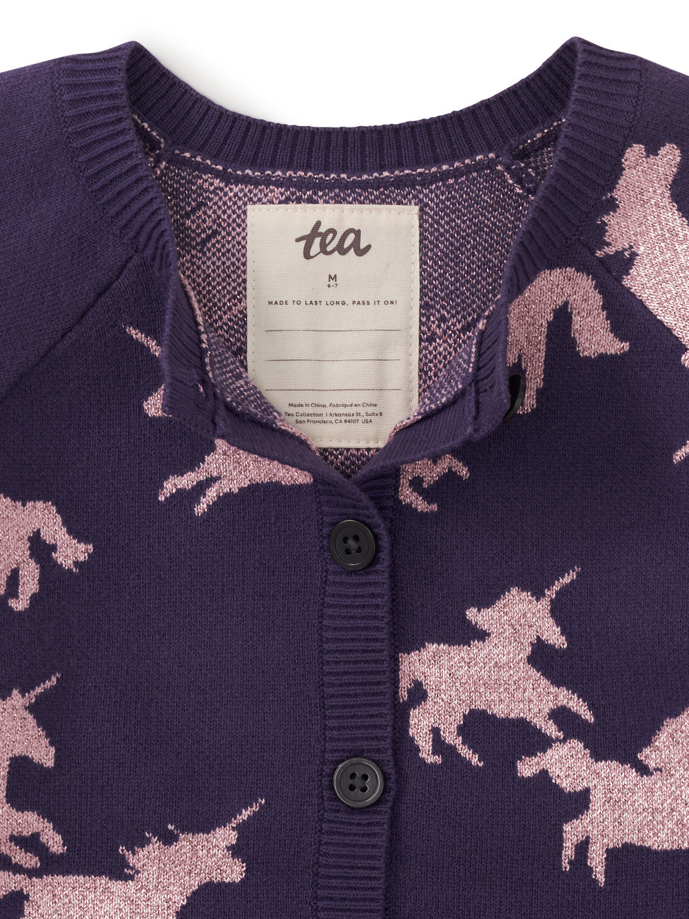 Purple cardigan with unicorn pattern and 'tea' brand label.