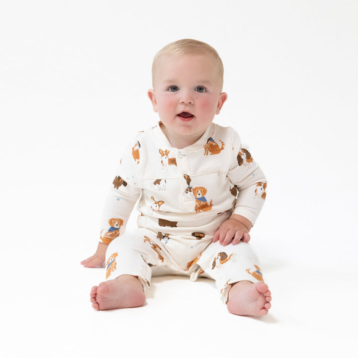 Baby wearing a white outfit with brown bear patterns on a white background