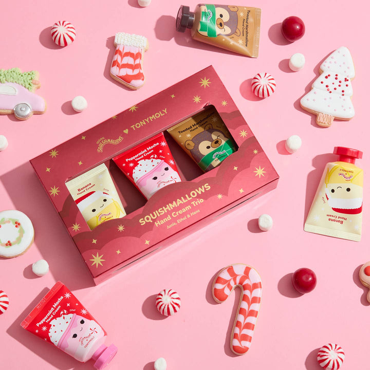 TONYMOLY Squishmallows hand cream trio set on a pink background with holiday-themed cookies and candies.