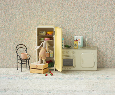 a scene in a kitchen with small bunny peering into the refrigerator