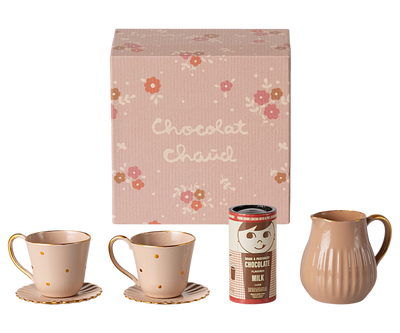 small floral box that contains 2 tin cups and saucers, pitcher and hot chocolate. 