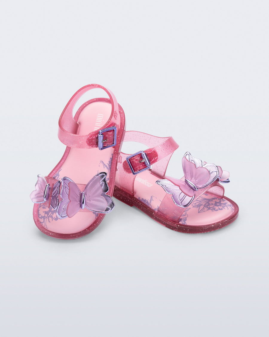 Pink children's sandals with butterfly designs on a light gray background