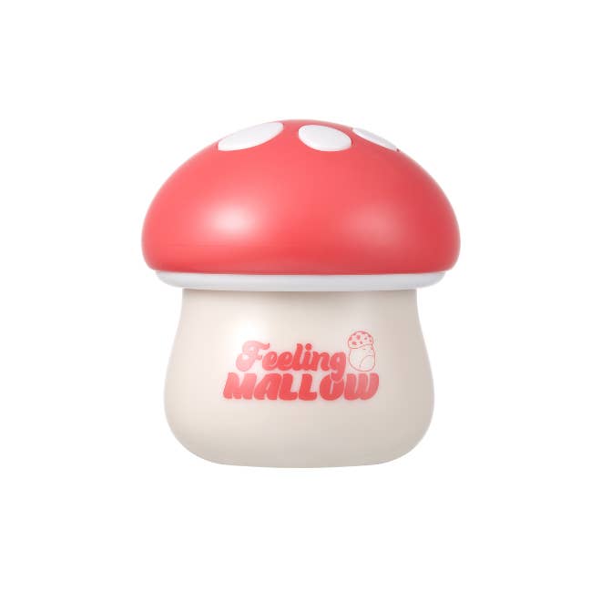 Mushroom-shaped container with red cap and white spots on a white background