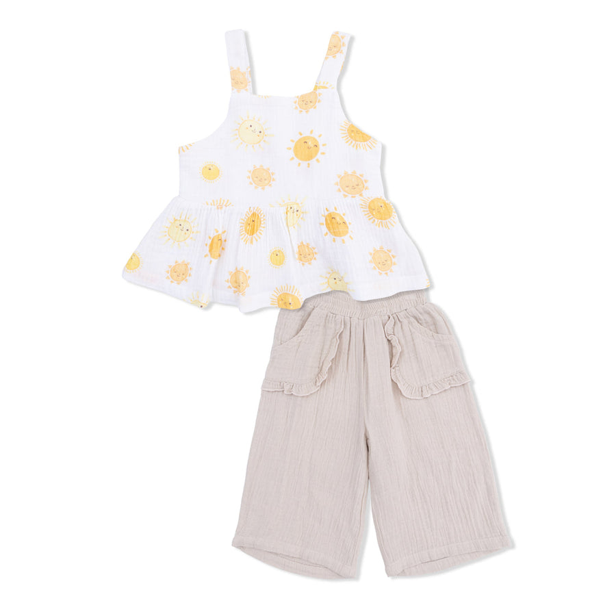Children's outfit with yellow suns on the  top and beige pants on a white background