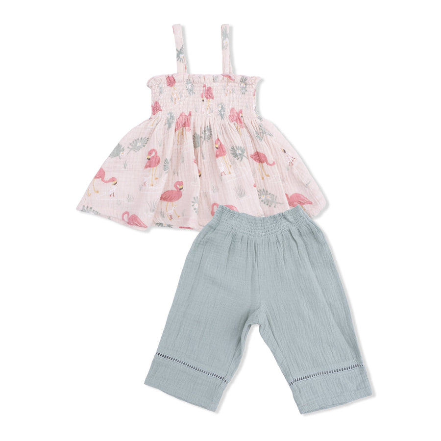 Children's outfit with pink floral top and light green pants on a white background