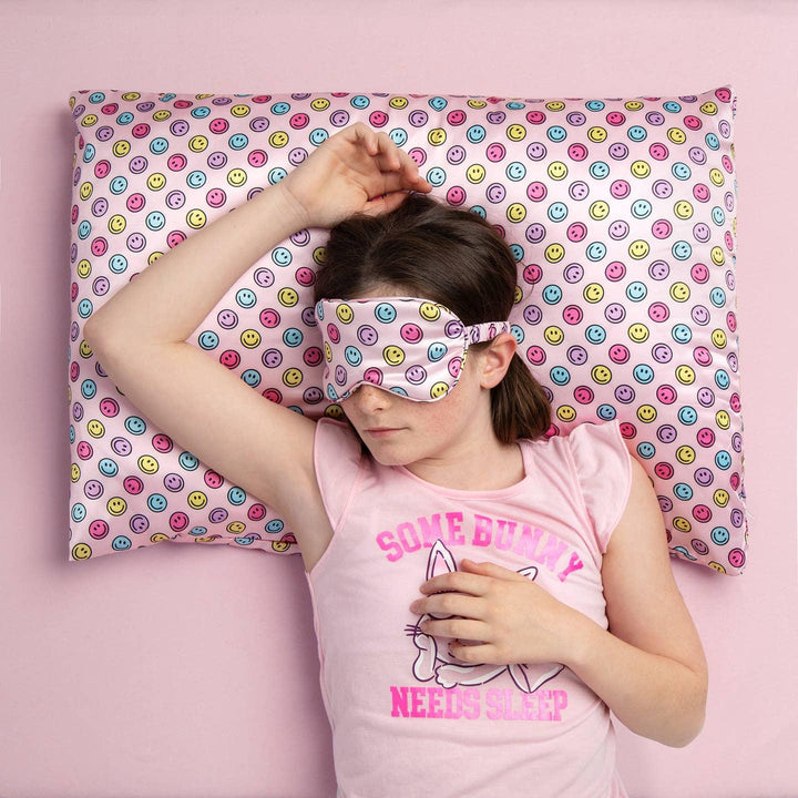 picture of young girl sleeping on the smiley face pillow case. 
