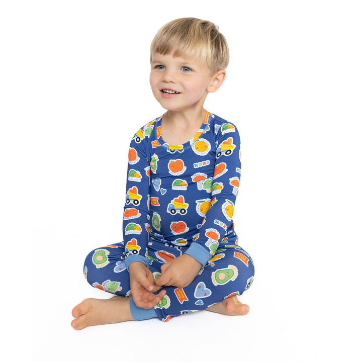 Child wearing a colorful pajama set with cartoon designs on a white background