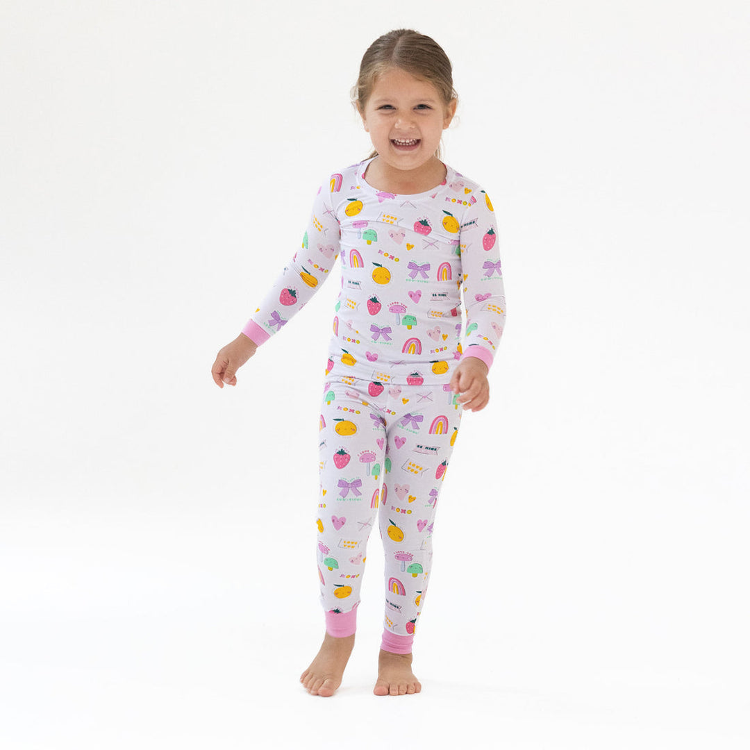 Child wearing a colorful pajama set with a white background