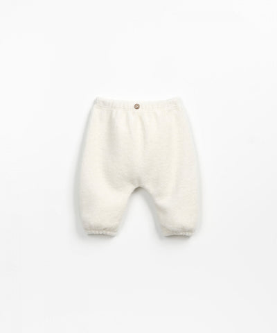 shot of baby pants on their own. beige fuzzy material with single wooden button at the top the of the waist