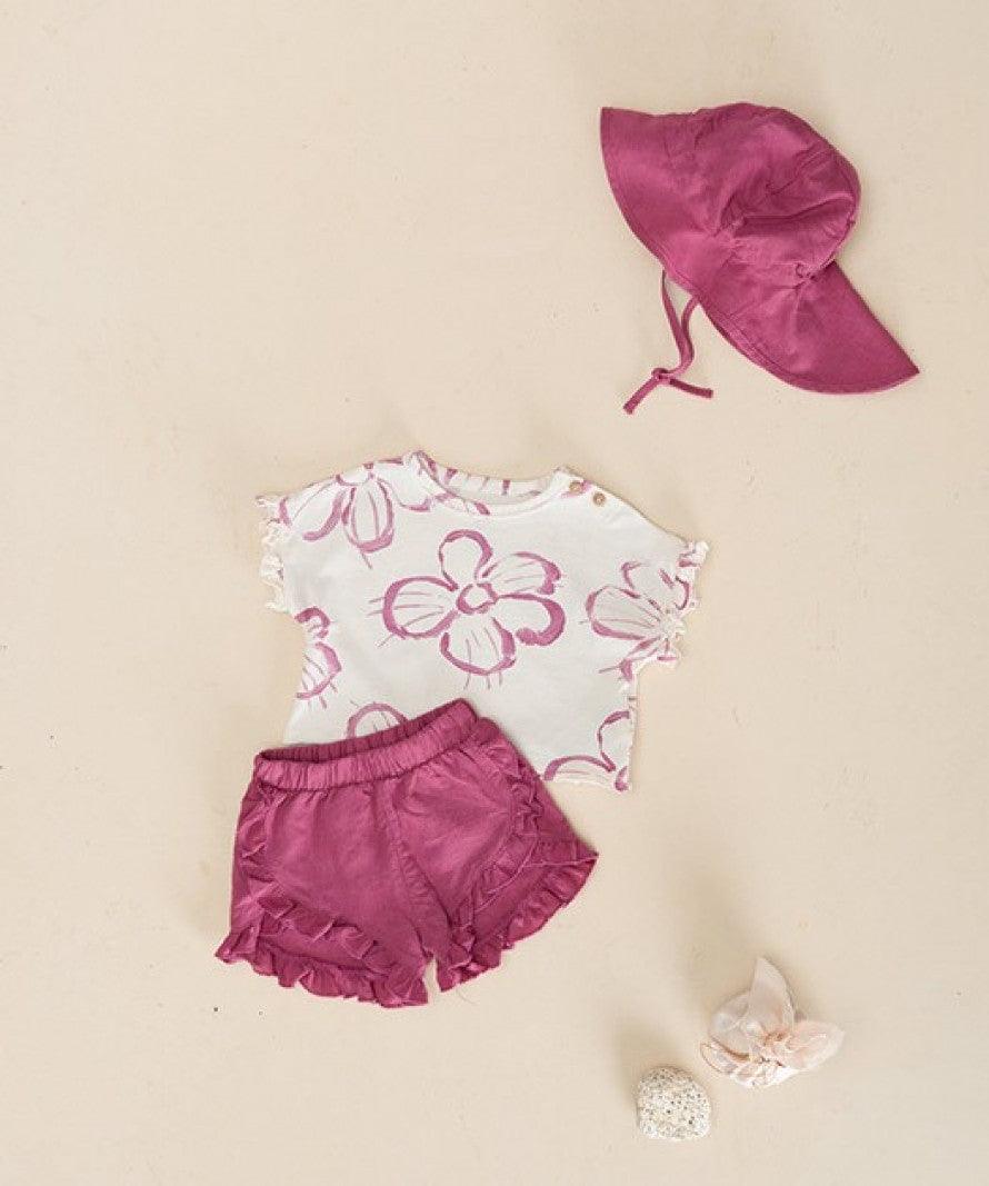 baby girl 2 piece set. ivory t-shirt with ruffle sleeves and big pink florals on it. deep pink linen shorts with ruffles along the edge. 