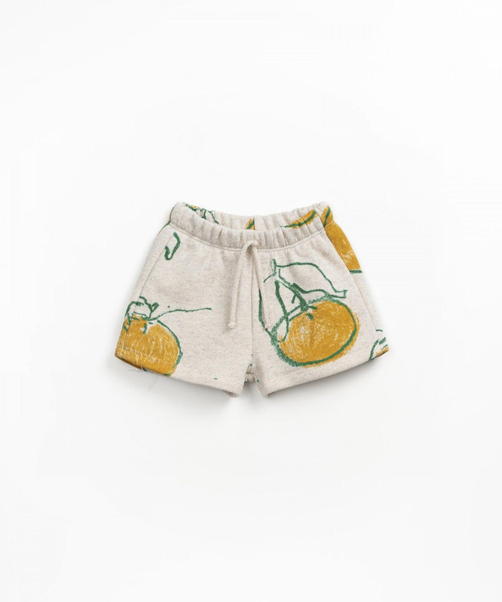 heathered biege shorts with big oranges and big green leaves attached to the oranges. drawstring at the waist. 