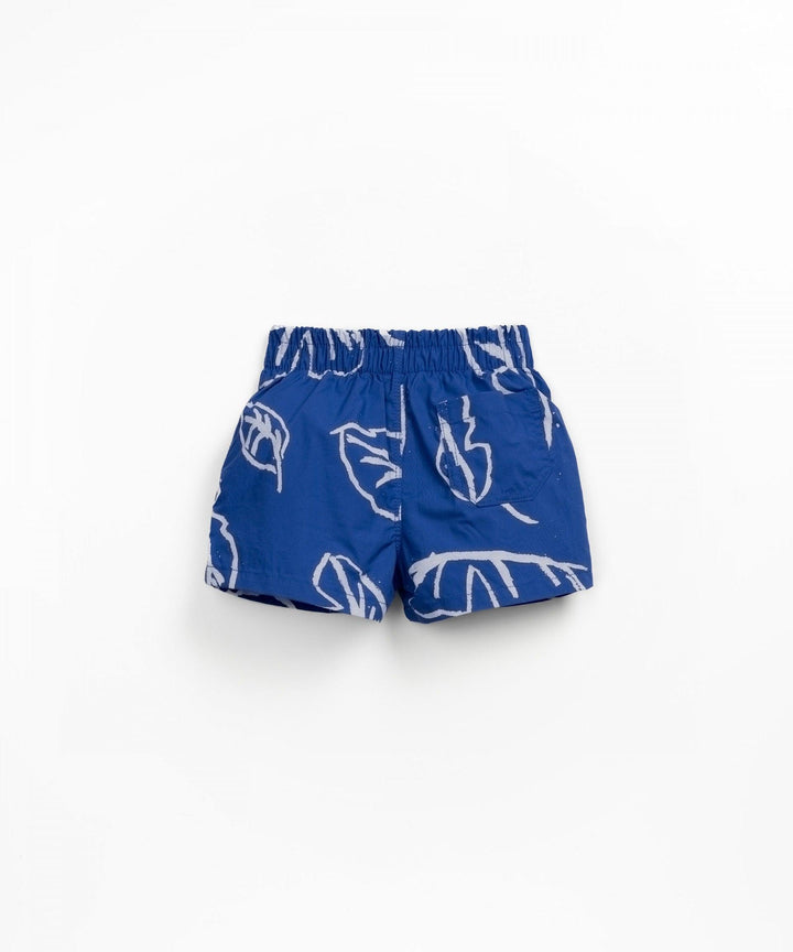 vibrant blue swim trunks with palm leaf design and small pocket on the back right side. 