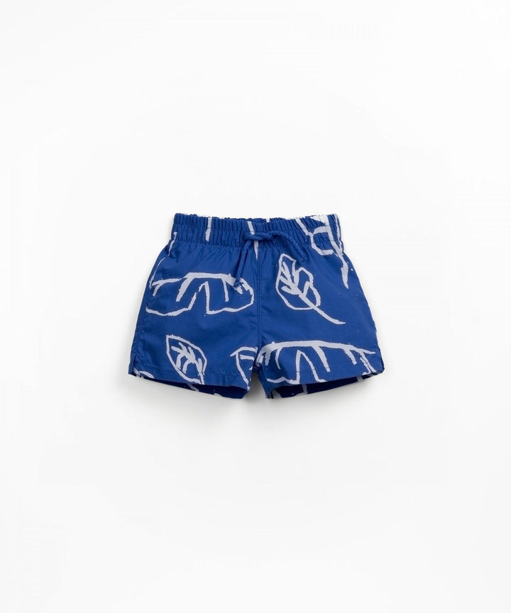 vibrant blue swim trunks with palm leaf design. drawstring waist. 