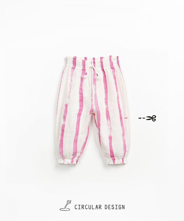 elastic waisted pants with elastic bottoms. white pants with dark pink vertical stripes going down the pants. 