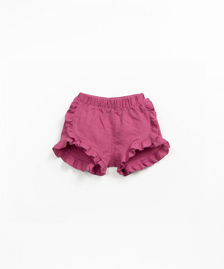deep pink linen shorts with ruffles at the bottom of the shorts. 
