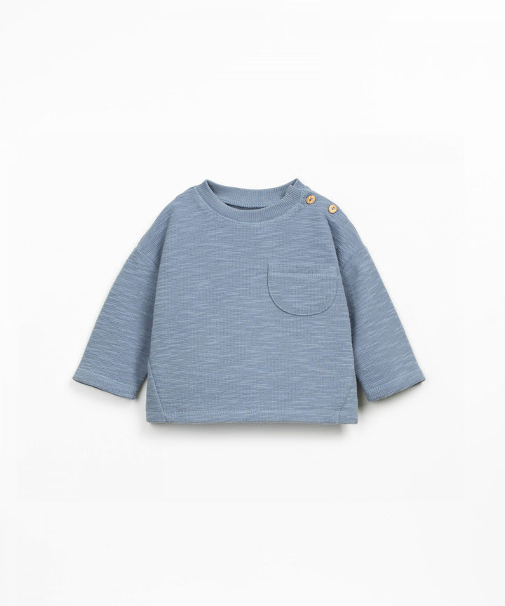 Blue ribbed baby long sleeve top on a white background