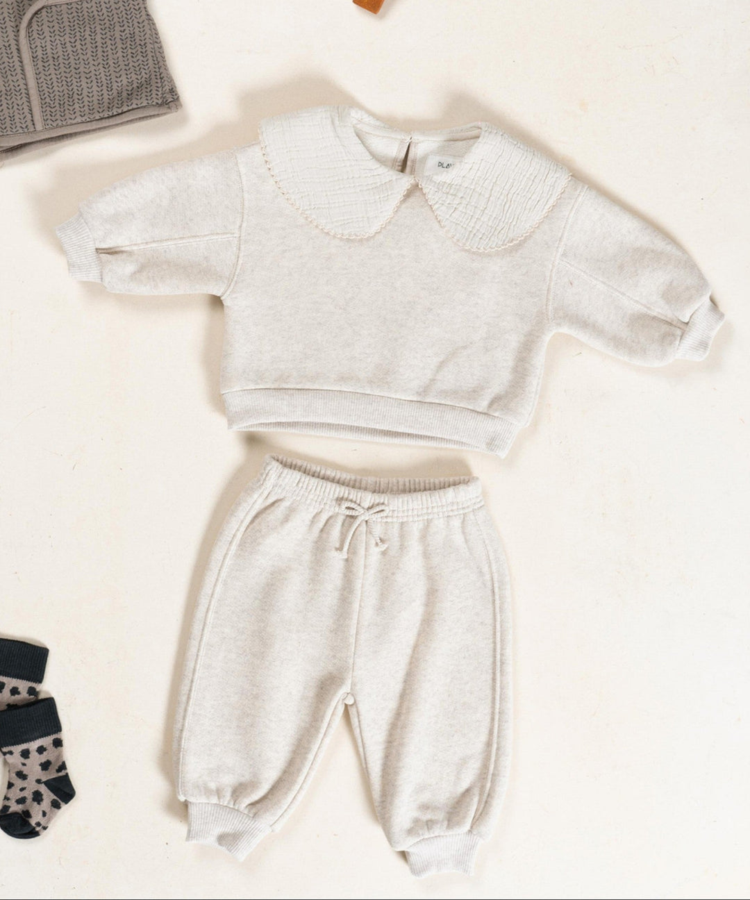 Children's clothing set with a sweater, pants, and socks on a white background