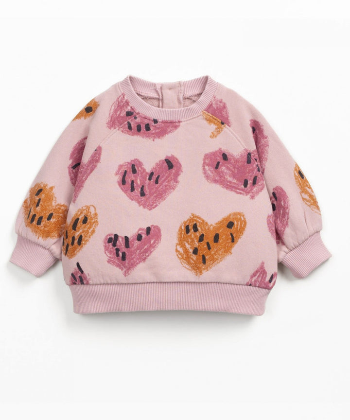 Pink children's sweatshirt with heart patterns on a white background