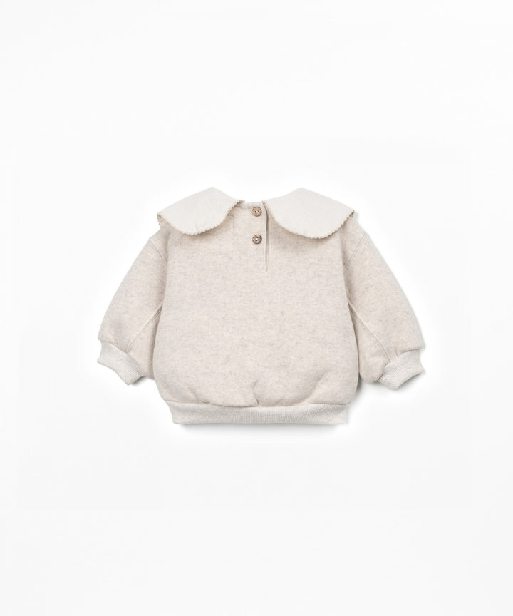 Beige baby sweater with a collar on a white background