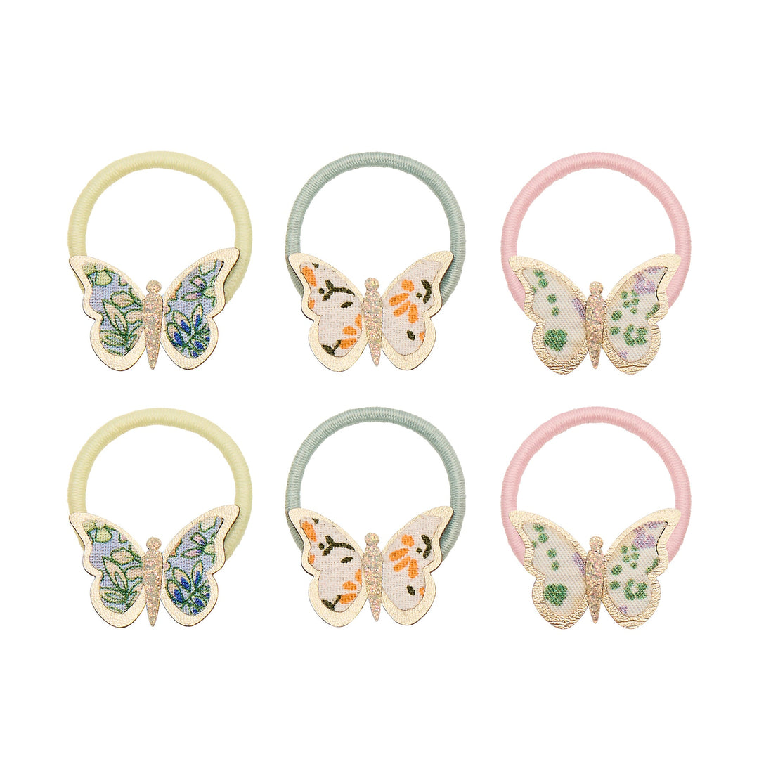Set of six butterfly-themed hair ties in pastel colors on a white background