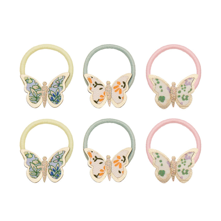 Set of six butterfly-themed hair ties in pastel colors on a white background