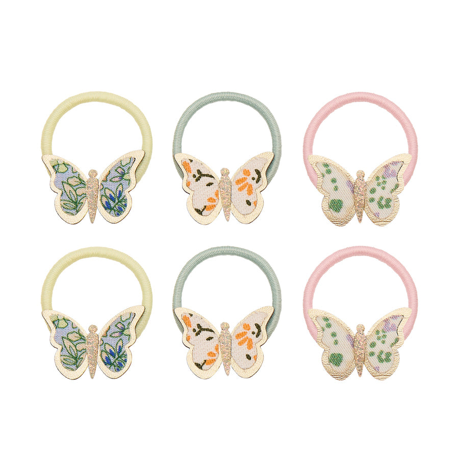 Set of six butterfly-themed hair ties in pastel colors on a white background