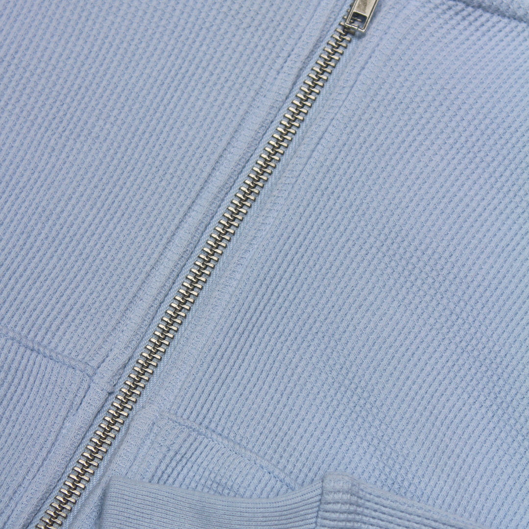Close-up of a light blue jacket with a zipper