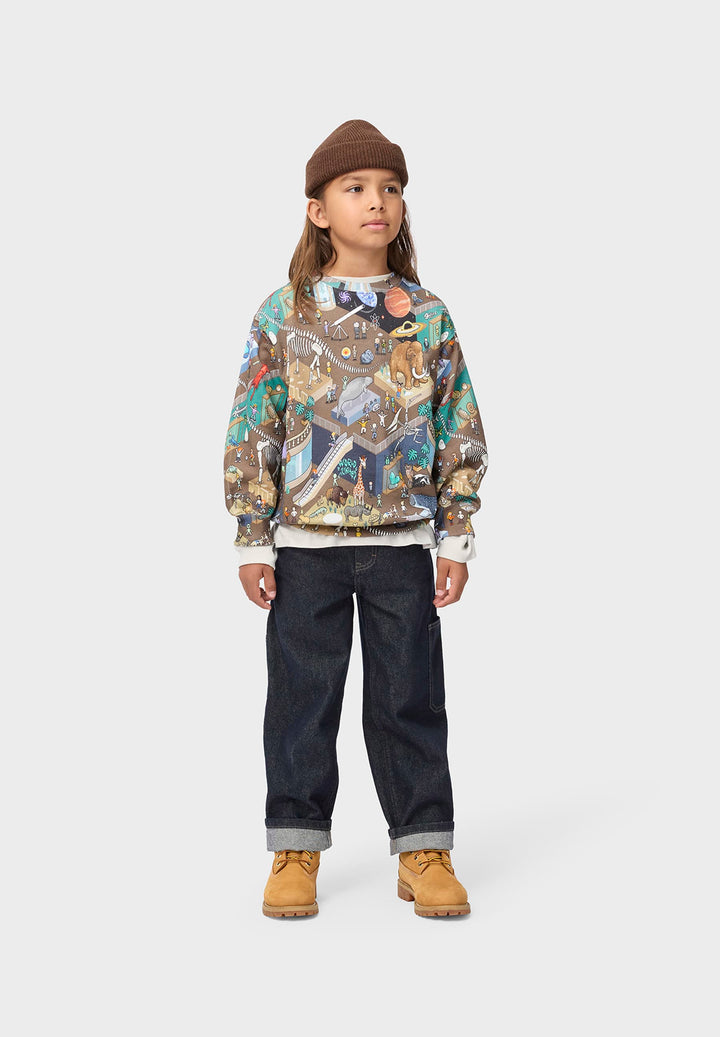 Child wearing a patterned sweatshirt dark pants, and brown boots on a white background