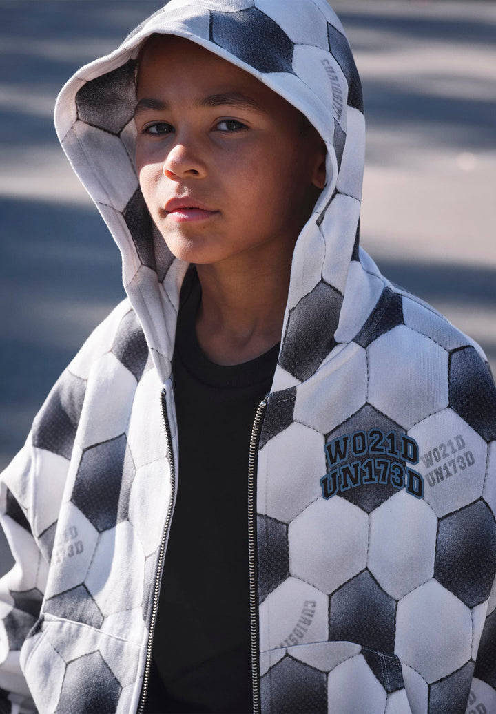 Person wearing a geometric patterned hoodie with a blurred background