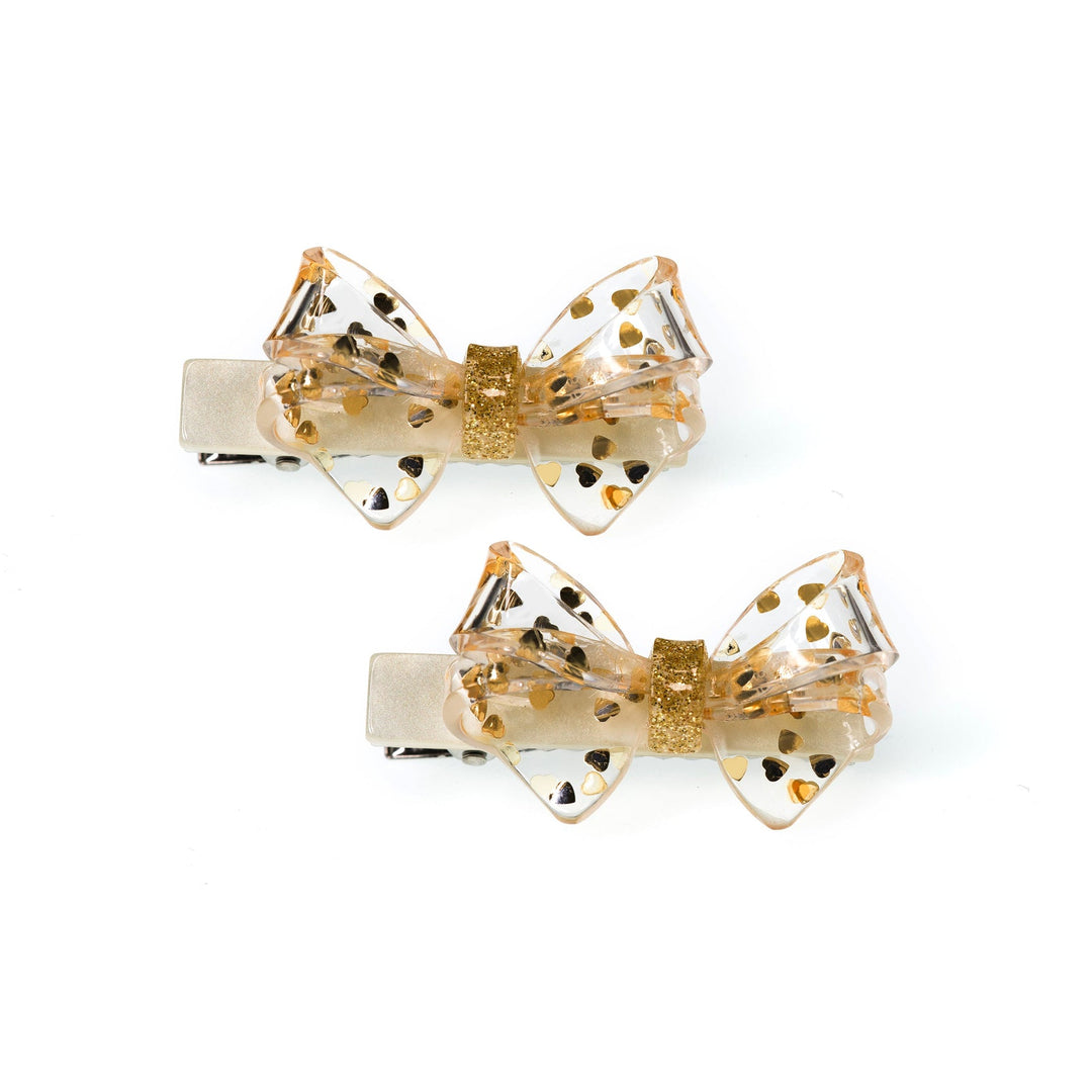 set of 2 clips with gold hearts in the actylic. bow shapes on the alligator clip. 