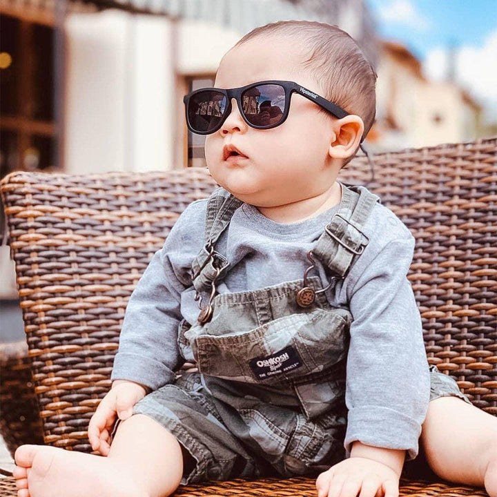 baby wearing black sunglasses with stay on strap