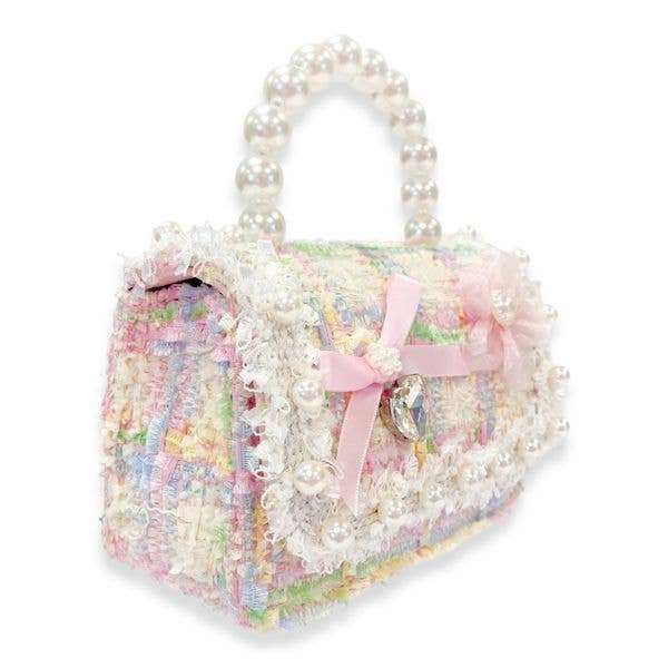 the sideview of the bag and pearl handle and embellishments on the pastel tweed handbag