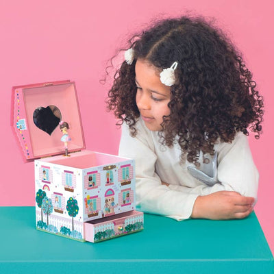 Little girl peering into the jewelry box watching the girl inside spin around. 