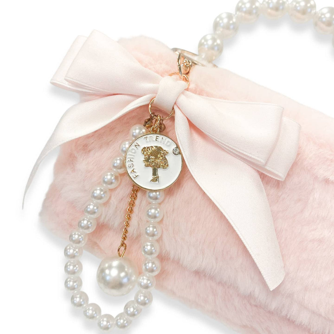 Pearl bracelet with a decorative charm on a pink background