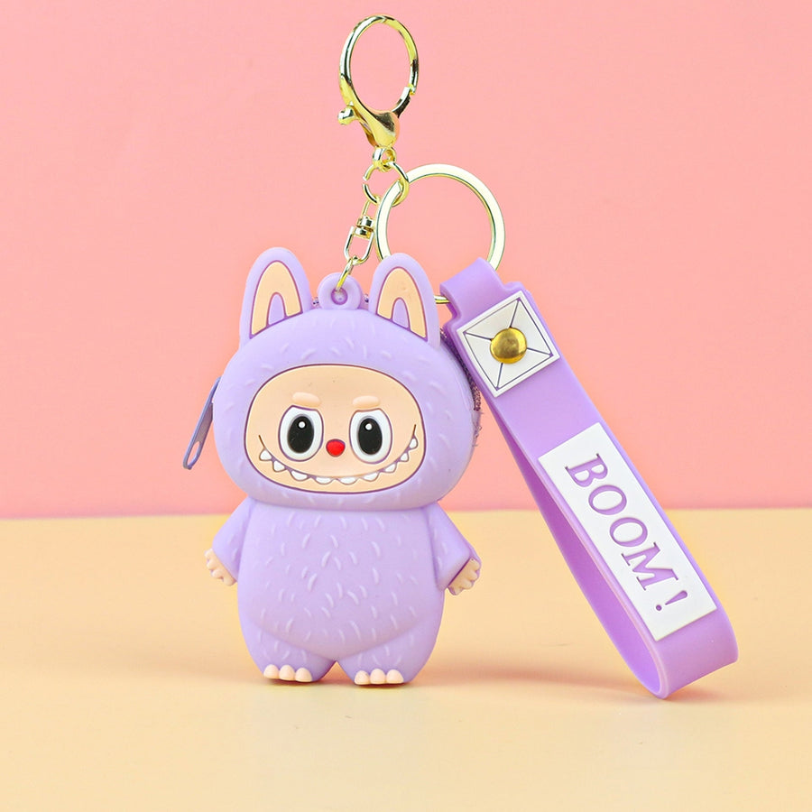 Purple labubu cartoon character keychain with 'BOOM!' tag on a pink and yellow gradient background