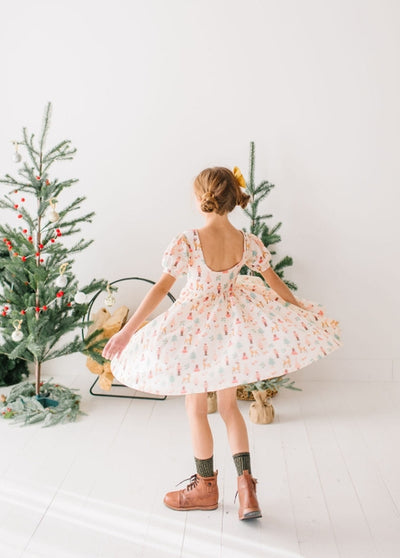 girl twirling in the nutcracker dress. beige ground with all over Nutcracker print