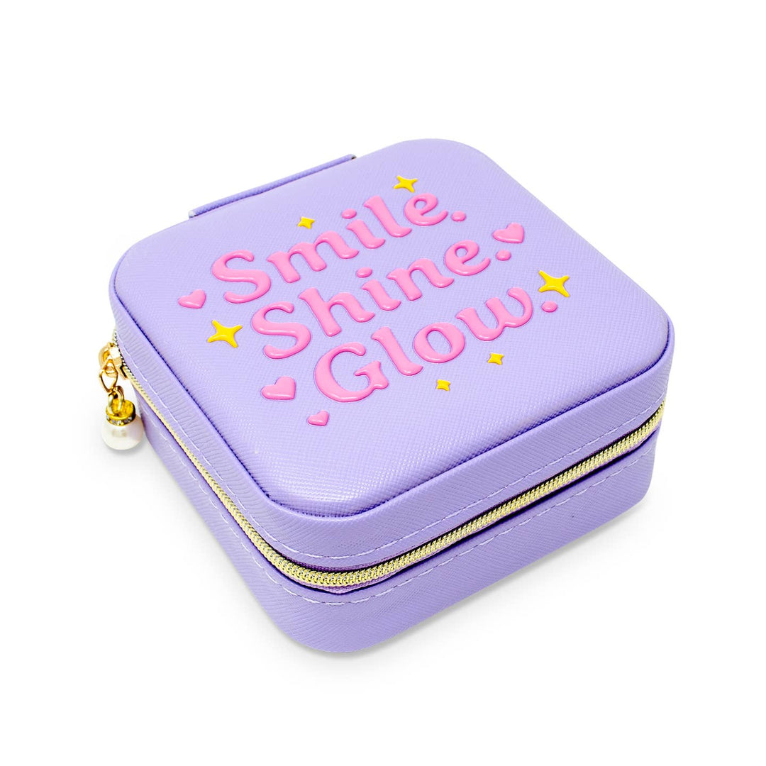 Purple jewelry case with 'Smile. Shine. Glow.' text on a white background