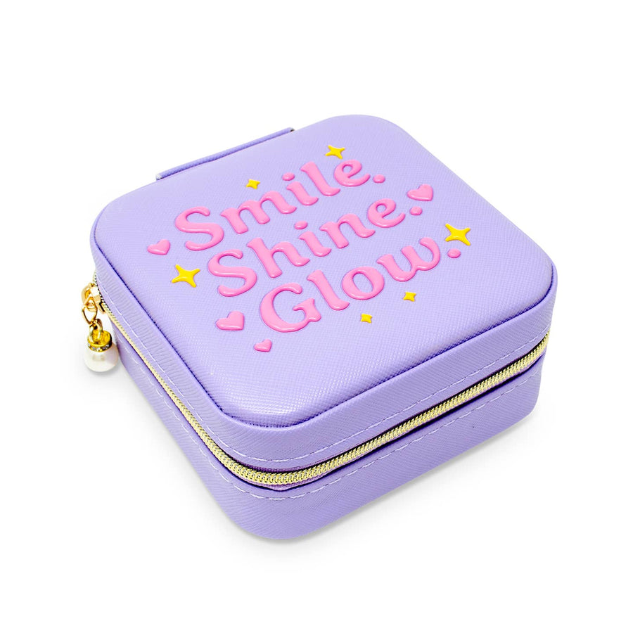 Purple jewelry case with 'Smile. Shine. Glow.' text on a white background