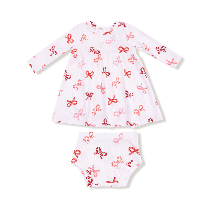 White baby dress with red candy cane bows patterns on a white background