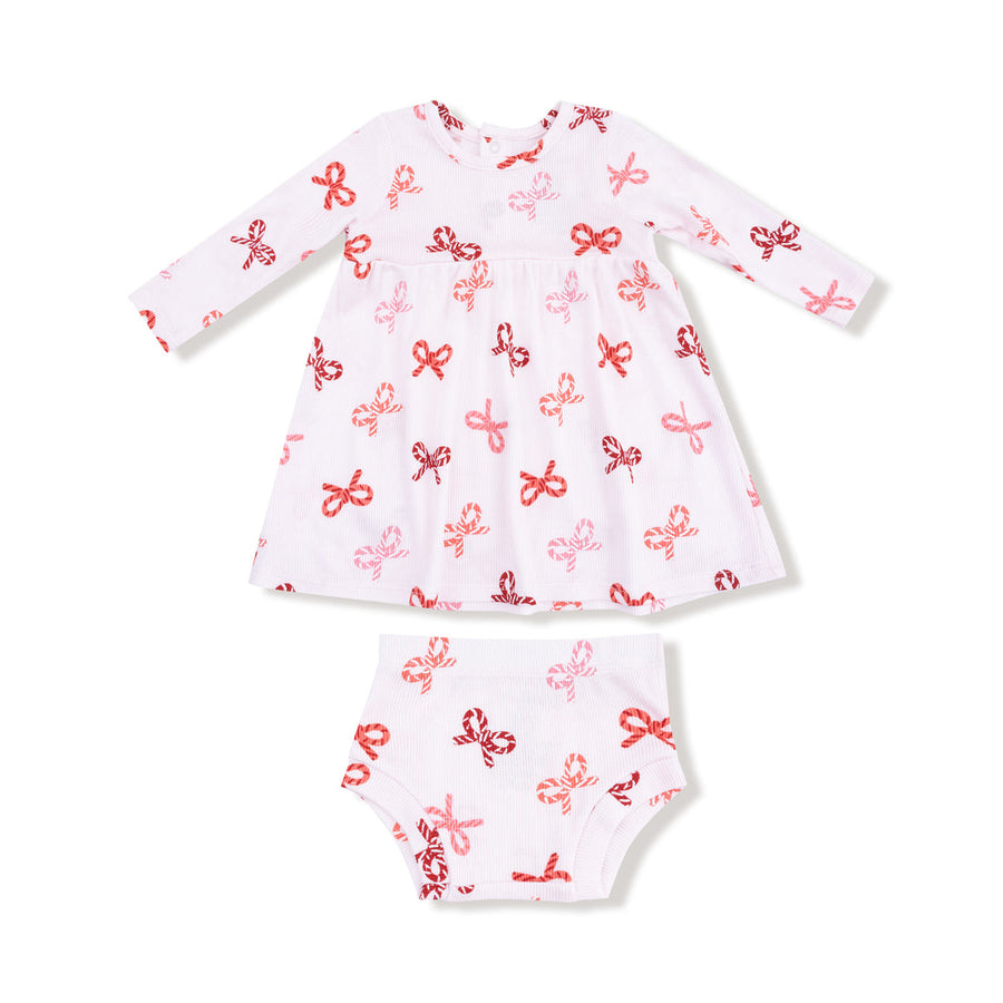 White baby dress with red candy cane bows patterns on a white background