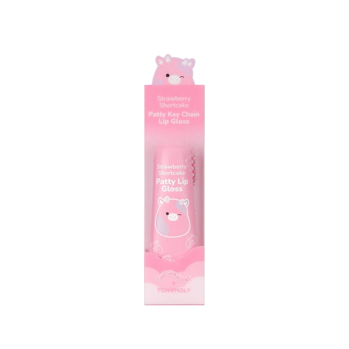 lip gloss in the shade of pink attached to a chainlink in packaging with the squishamllow cow charachter attached to it/on the box. 